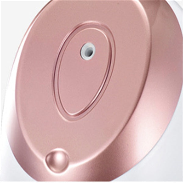 Rose gold circular object with a central hole on a white background